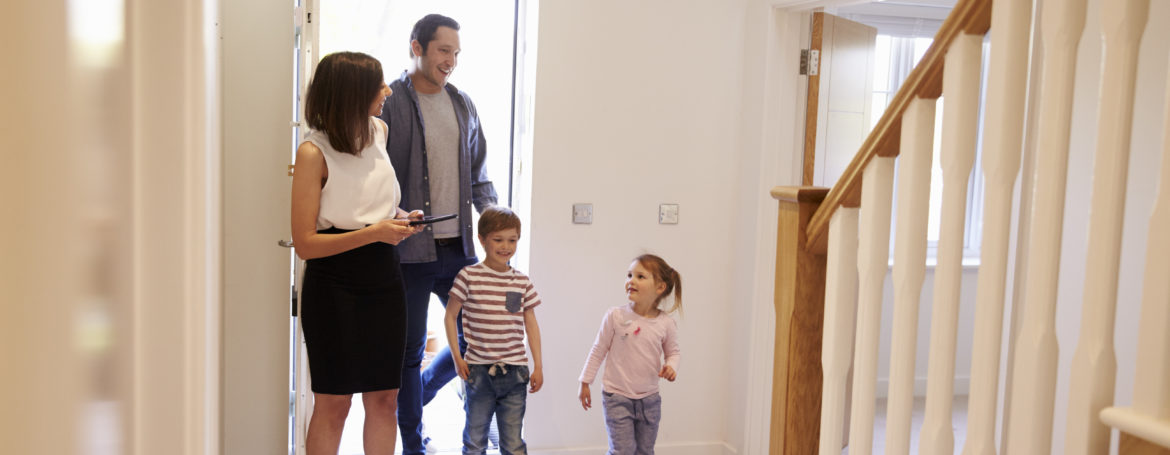 Realtor Showing Young Family Around Property Listing
